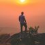 homme an randonnée dans la montagne admirant le coucher du soleil pour se reconnecter à lui-même et à la nature