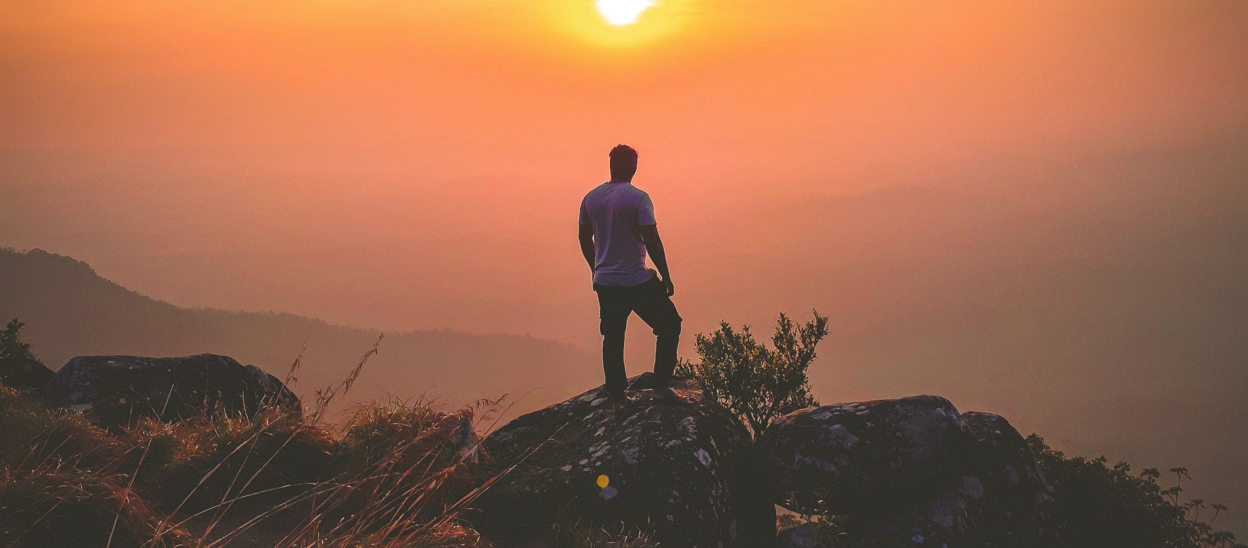 homme an randonnée dans la montagne admirant le coucher du soleil pour se reconnecter à lui-même et à la nature